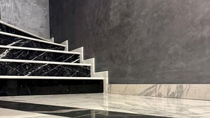 A staircase with black and white marble steps leading up to a dark wall. - d'or Hotel (Codru)