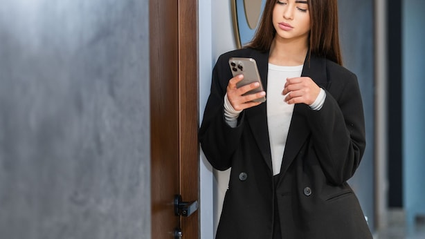 A person in a black suit standing in a hallway with a wooden door and three oval mirrors on the wall. - d'or Hotel (Codru)