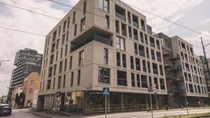 A modern multi-story building with a flat facade, large windows, and balconies. - Camelia Apartament Balkon Gara (Bydgoszcz)