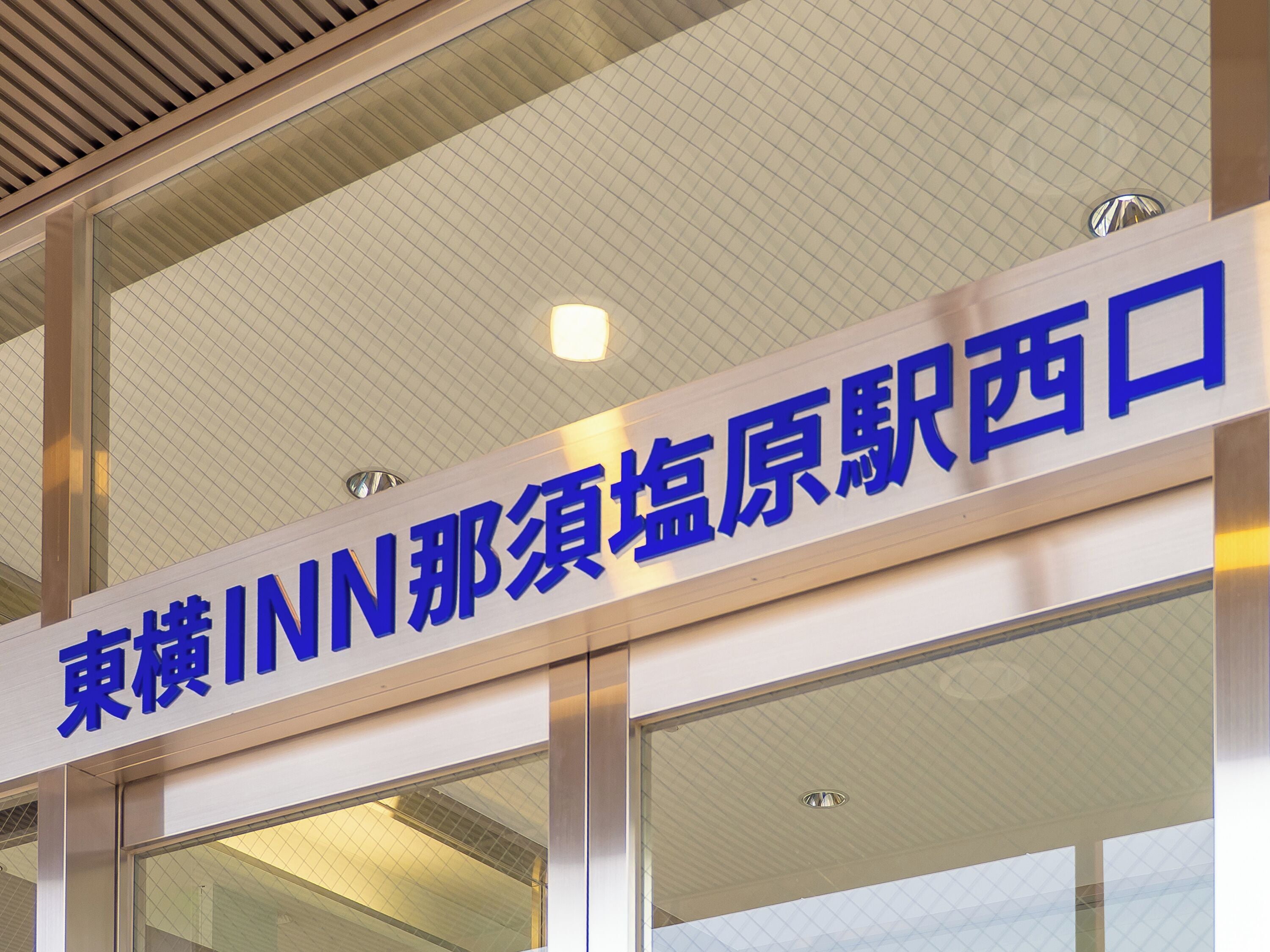 A sign with blue text on a building facade.