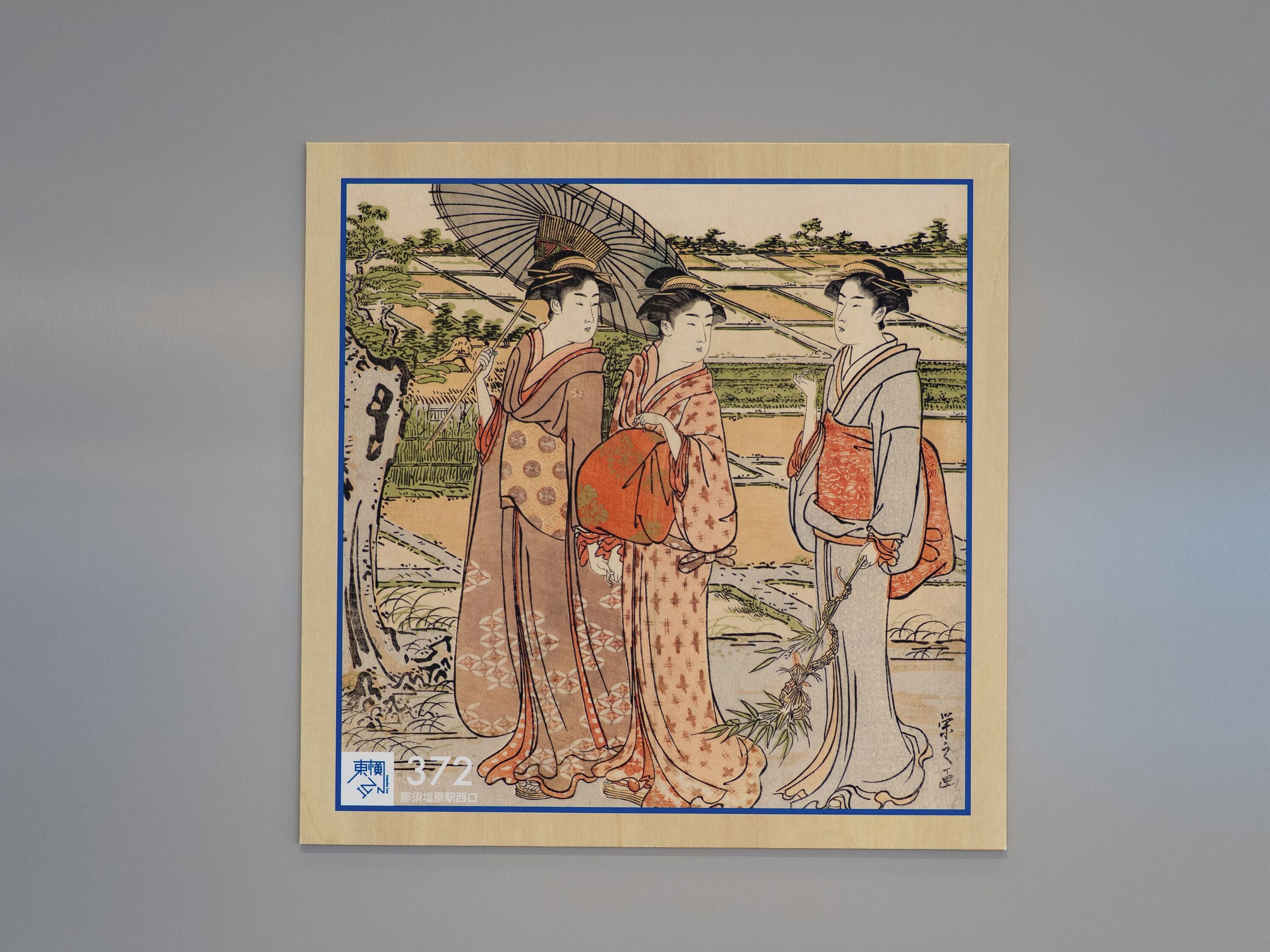 A traditional Japanese artwork with three figures, a fan, and bamboo.