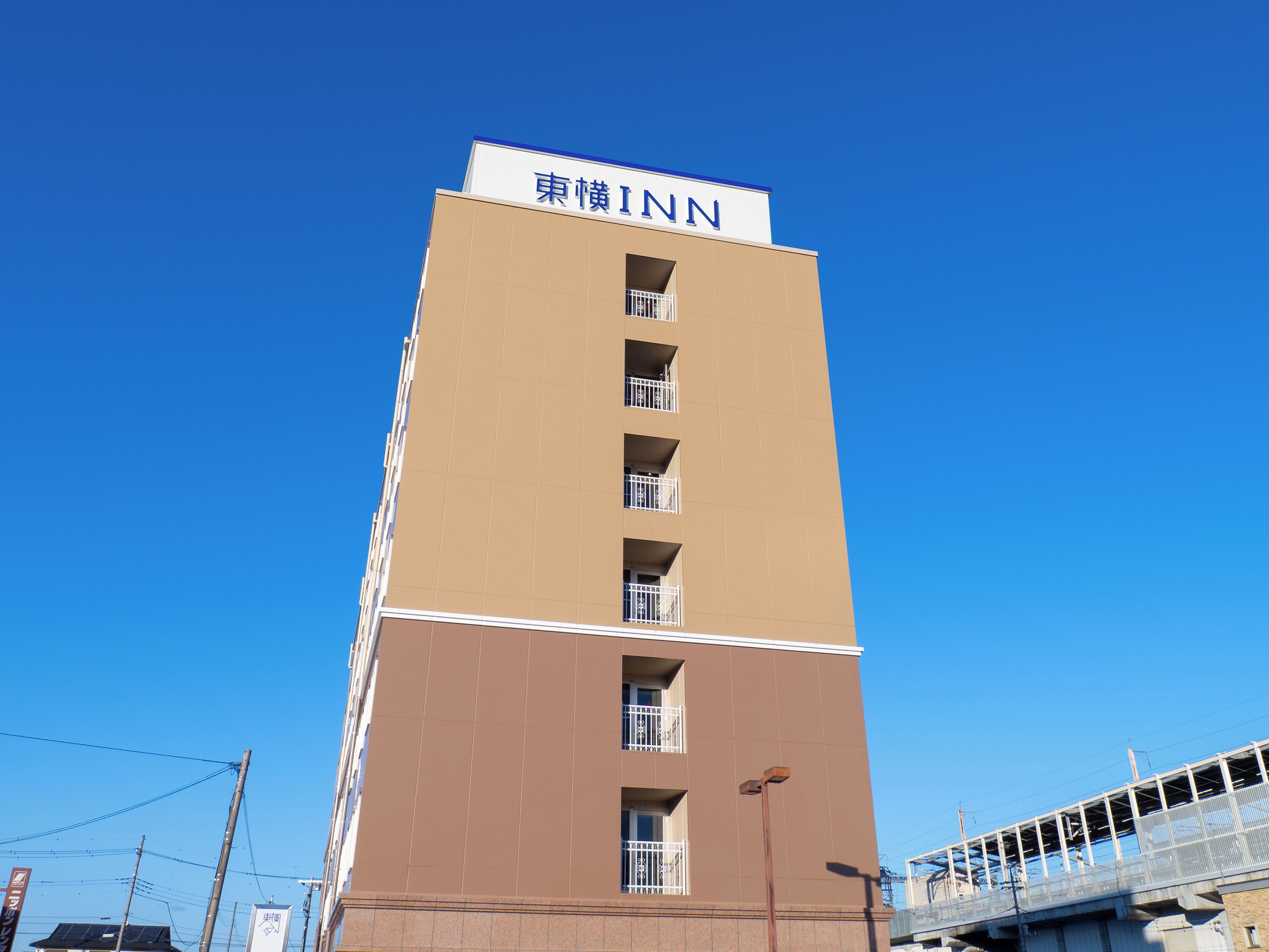 Un hotel alto con un letrero que dice '  東横工INN' en la parte superior.