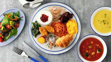 Una mesa con varios platos, incluyendo una ensalada, un plato con huevos, verduras y un tazón de sopa.