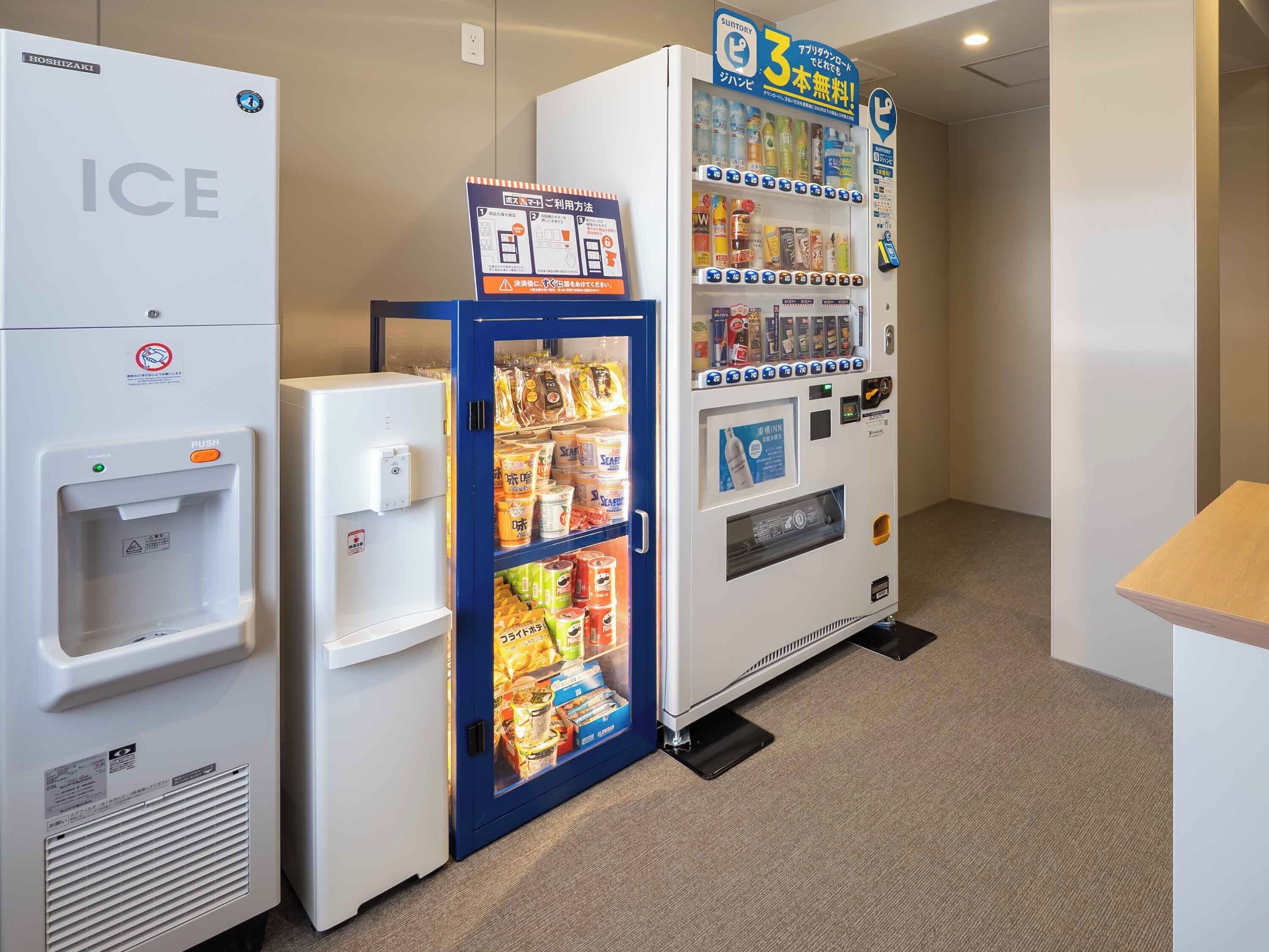 A vending machine with various snacks and drinks, a water dispenser, and a refrigerator labeled 'ICE'.