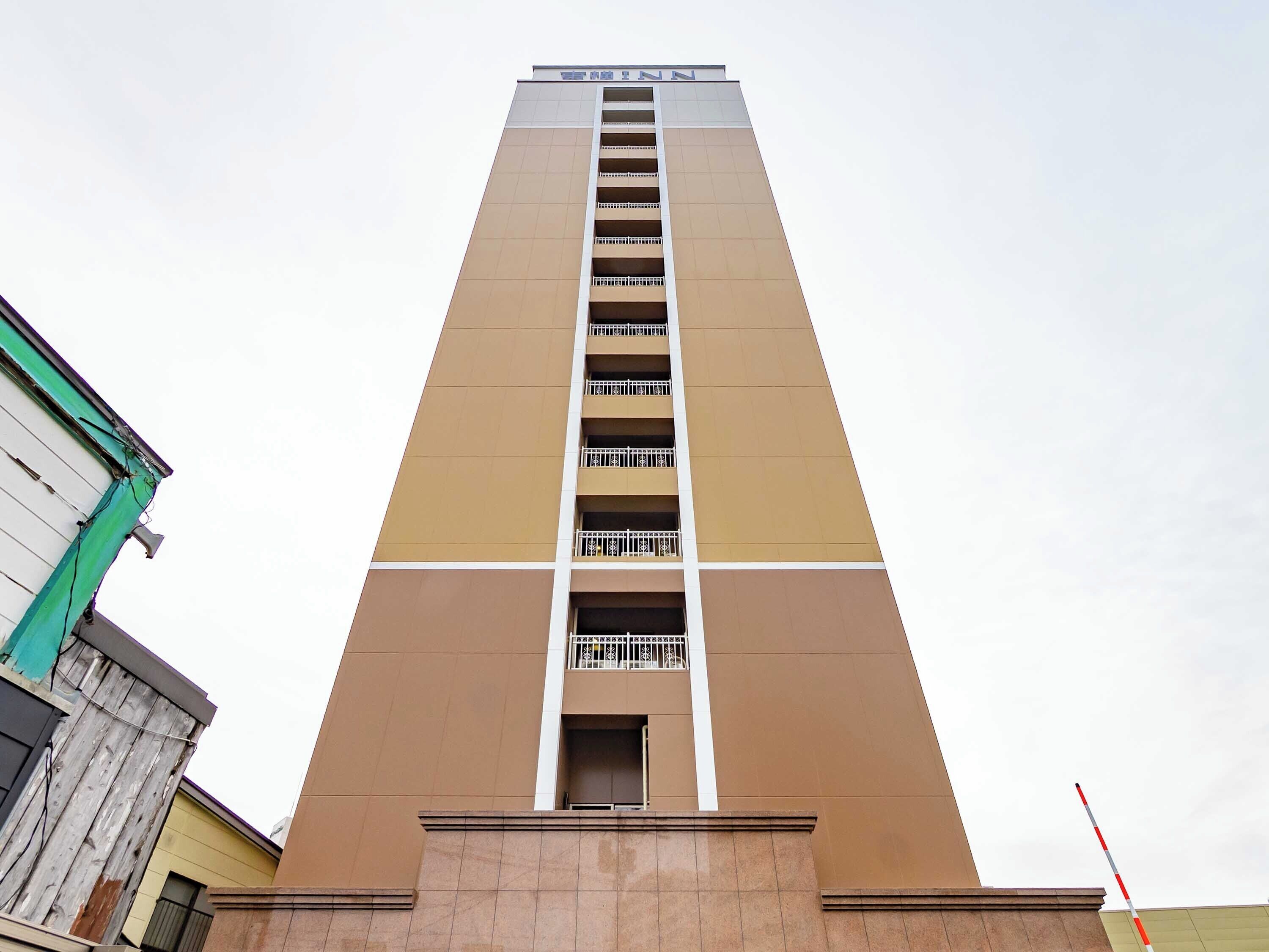 Un edificio alto con varios balcones y un letrero en la parte superior.