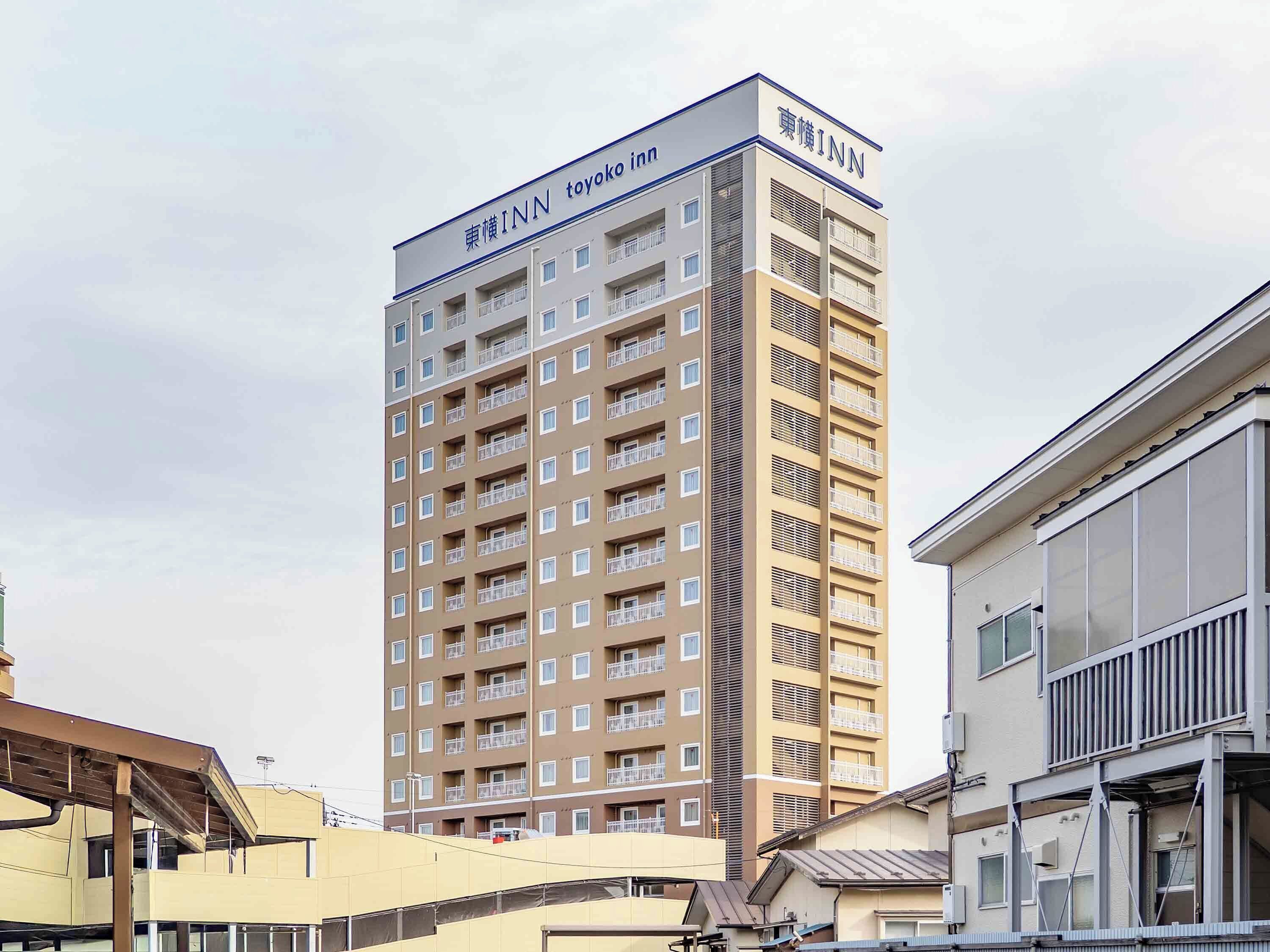Un edificio de varios pisos con el letrero 'Toyoko Inn' en la parte superior.