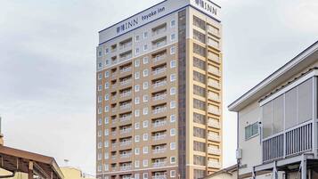 Un edificio de varios pisos con el letrero 'Toyoko Inn' en la parte superior.