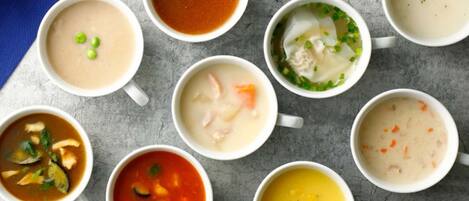 Nine bowls of soup arranged on a table.
