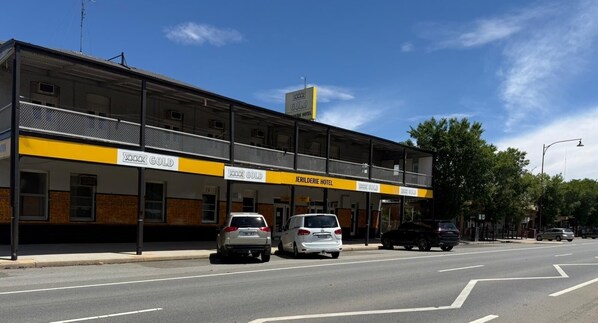 A hotel named 'Jerilderie Hotel' with multiple 'XXX Gold' signs, parked cars, and a clear sky. - Jerilderie Hotel (Jerilderie)