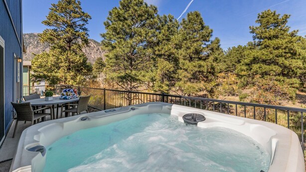 A hot tub with a clear view of surrounding trees and a mountain in the background. - 4BR w hot tub, EV charger, mountain views (Flagstaff)