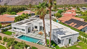 Ein modernes Haus mit Pool, Solaranlage und Bergblick.
