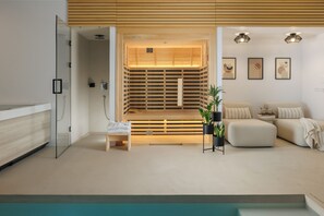 A modern spa room with a wooden sauna, a seating area with a sofa and cushions, and a small table with a plant. - Villa Amoreta wellness & spa (Istria - Županići) (Županići)