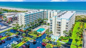 Un hôtel comprenant plusieurs étages, une piscine et un parking.