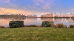 A serene lakeside view with manicured lawns and hedges.