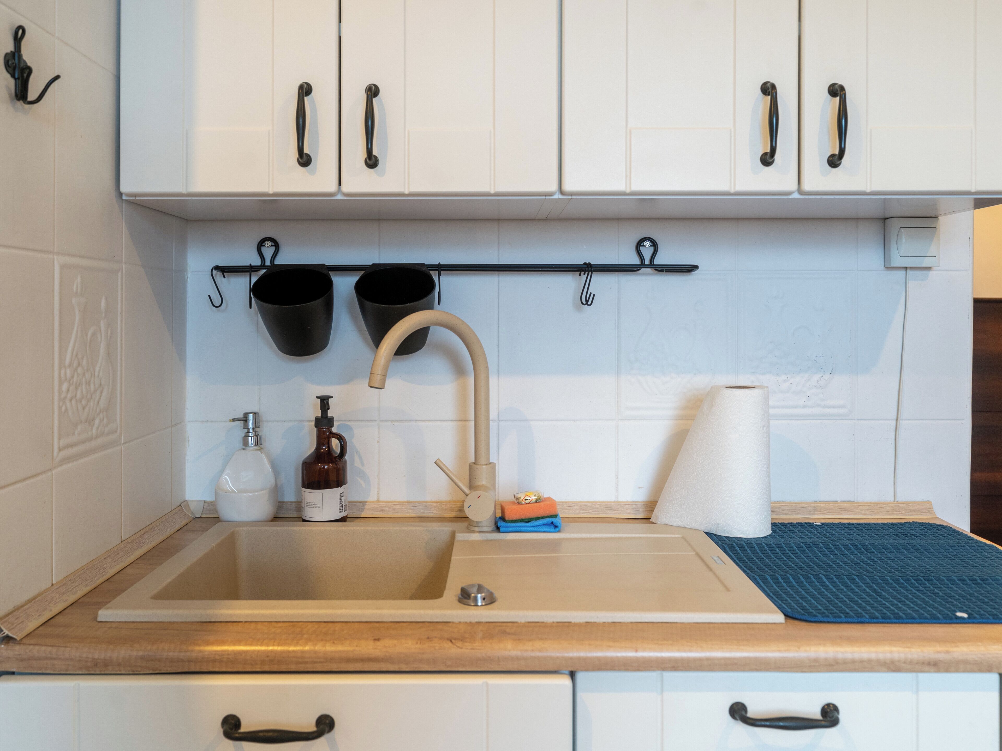 A kitchen with white cabinets, a sink, and a countertop.