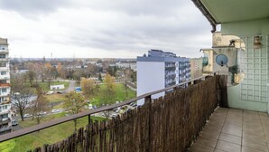 Ein Balkon mit Blick auf ein Wohngebiet, einschließlich Gebäude und einer Straße.