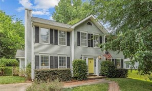 A two-story house with a front entrance, a small porch, and a well-maintained lawn. - MINS TO ATRIUM HEALTH, CAROWINDS, AMP BALLANTYNE (Charlotte)