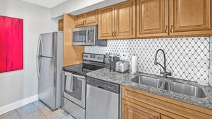 Una cucina moderna con elettrodomestici in acciaio inossidabile, mobili in legno e un piano di lavoro in granito.