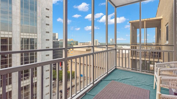 Un balcone con vista su edifici cittadini e cielo sereno.