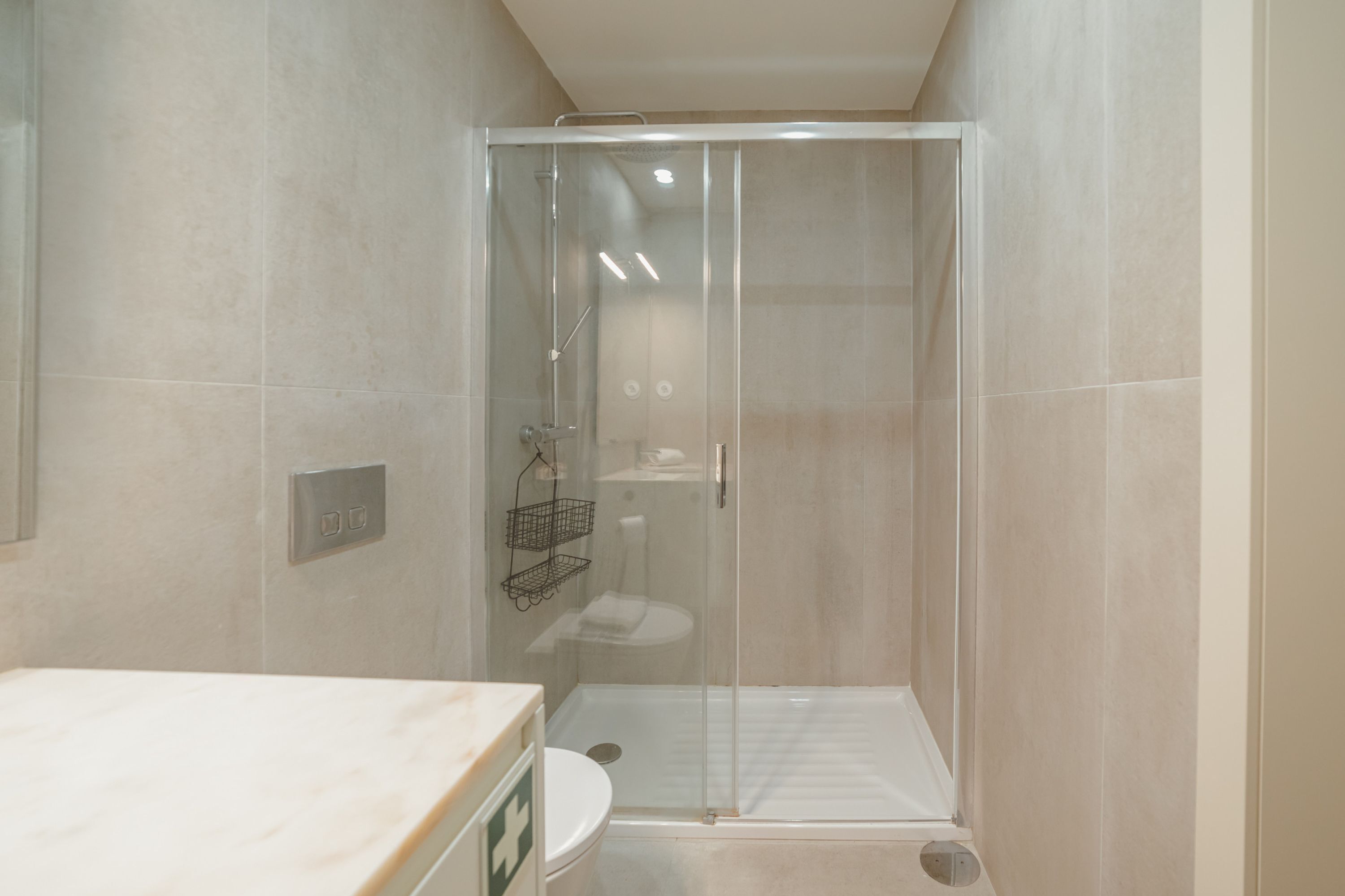 Une salle de bain moderne avec une douche à parois de verre, des toilettes et un lavabo avec un miroir.