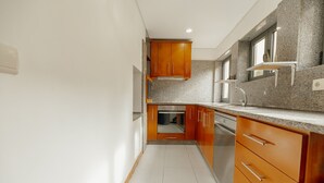 Una cocina con armarios de madera, encimeras de granito y un lavamanos de acero inoxidable.