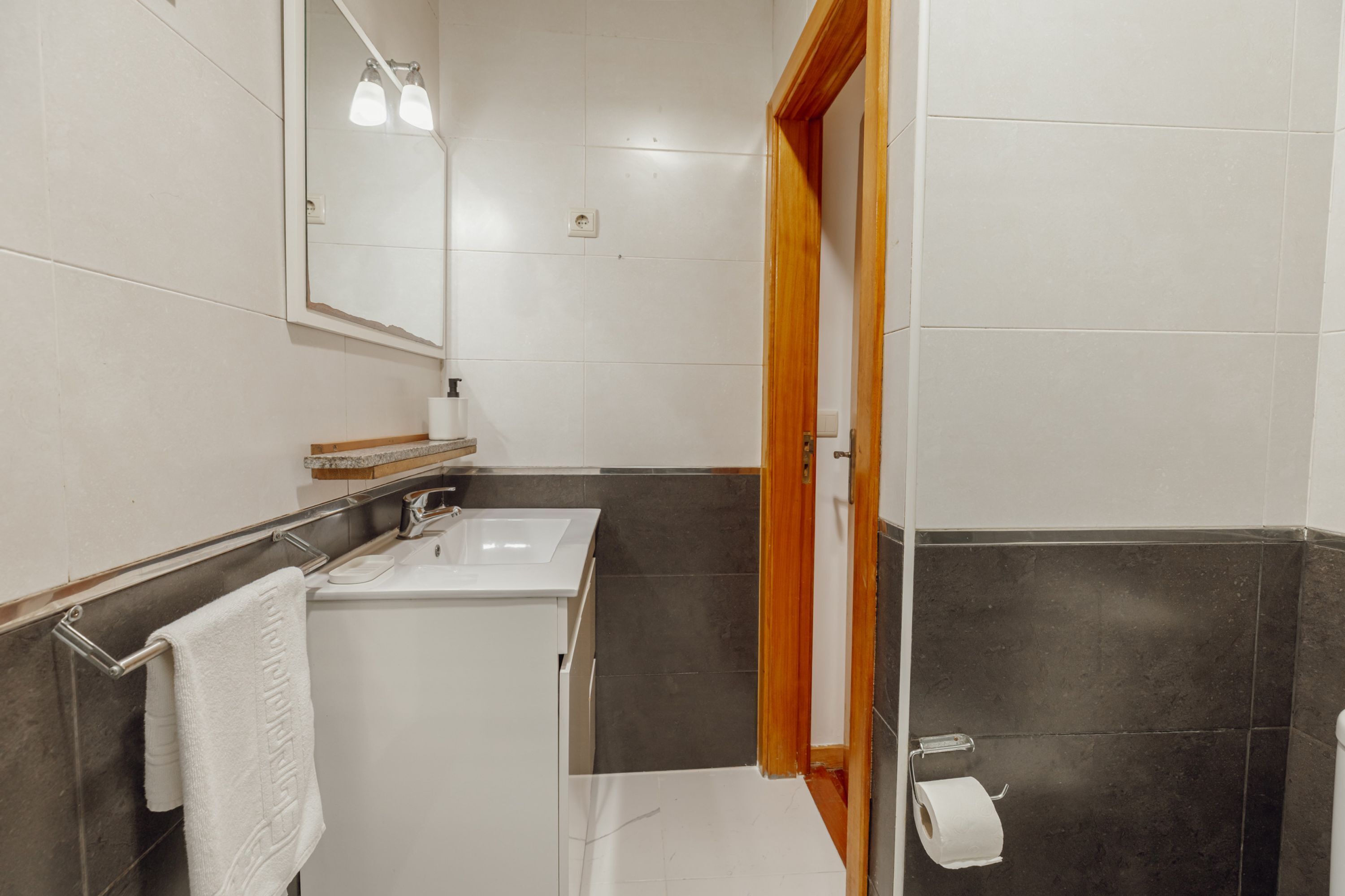 Uma casa de banho com duas pias, um espelho e uma sanita.