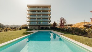 A modern building with a pool in front.