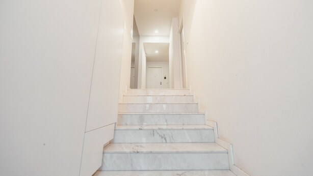 A staircase with white walls and a light fixture at the top. - Rooftop Constitui AO by Vacationy (Porto)