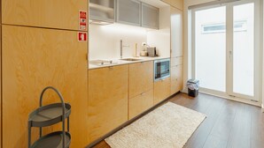 Eine moderne Küche mit Holzausstattung, einer Edelstahl-Spüle und einem eingebauten Backofen.