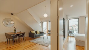Een modern appartement met een eethoek, een bank en een bed.