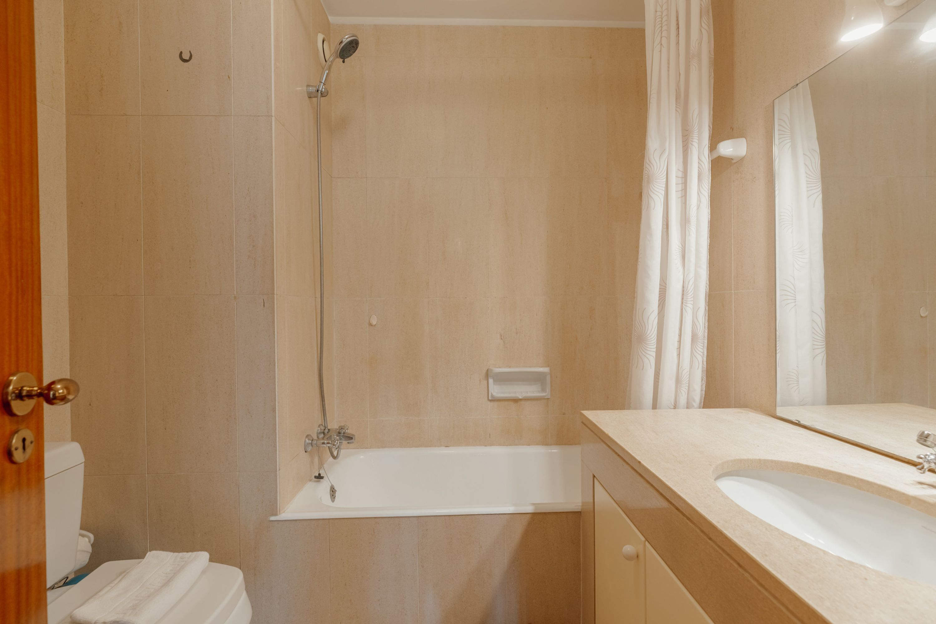 Un baño con bañera, lavabo e inodoro.