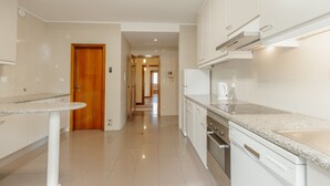 Una cocina moderna con armarios blancos, encimera de granito y horno empotrado.