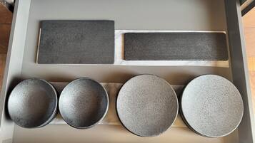 A drawer with various kitchenware items including plates and a rectangular tray.