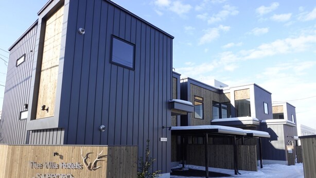 A modern hotel with a wooden facade and a snow-covered entrance. - The Villa Hotels -SAPPORO- (Sapporo)