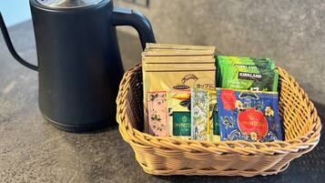 A black electric kettle and a wicker basket containing tea bags.