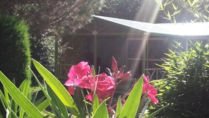 A garden with a gazebo, green foliage, and pink flowers. - Gitotel 1-Bedroom Chalet for 2 People (ST JEAN DU GARD)