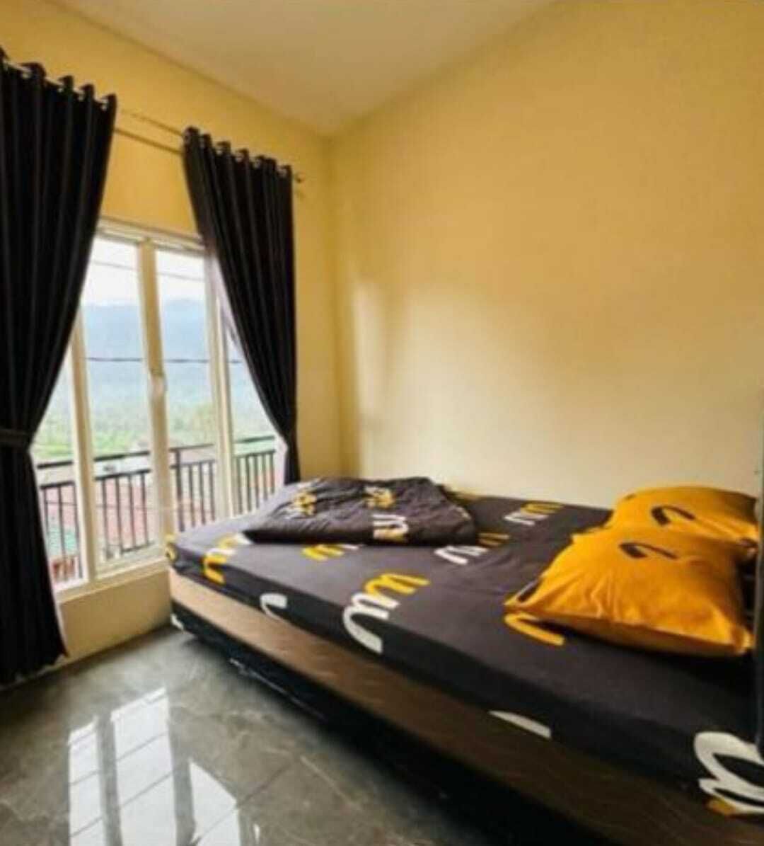 Ein Zimmer mit einem Bett, einem Vorhangfenster und Blick ins Freie.