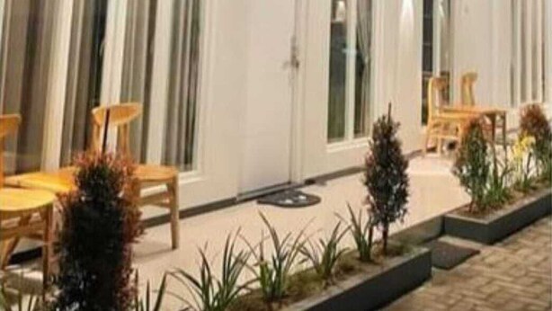 A modern building with large windows, a flat roof, and outdoor seating. - Fan Family Bromo Homestay (Ngadisari)