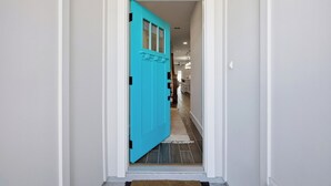 A hallway with a bright blue door leading to a room. - 5-Min Walk to Beach | Good Morning Rentals (Jacksonville Beach)
