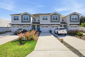 A two-story townhouse with a garage, a front door, and a driveway. - 5-Min Walk to Beach | Good Morning Rentals (Jacksonville Beach)