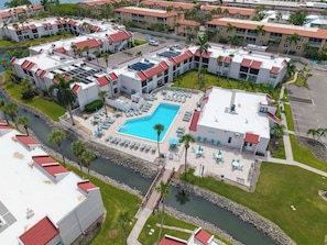 Un complexe hôtelier comprenant plusieurs bâtiments, un espace piscine central et une rivière.