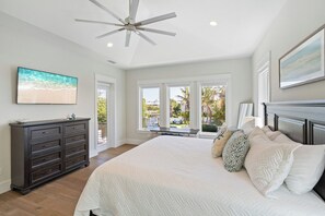A bedroom with a large bed, a ceiling fan, a dresser, and a view of the outdoors. - Yacht Sea (Anna Maria)