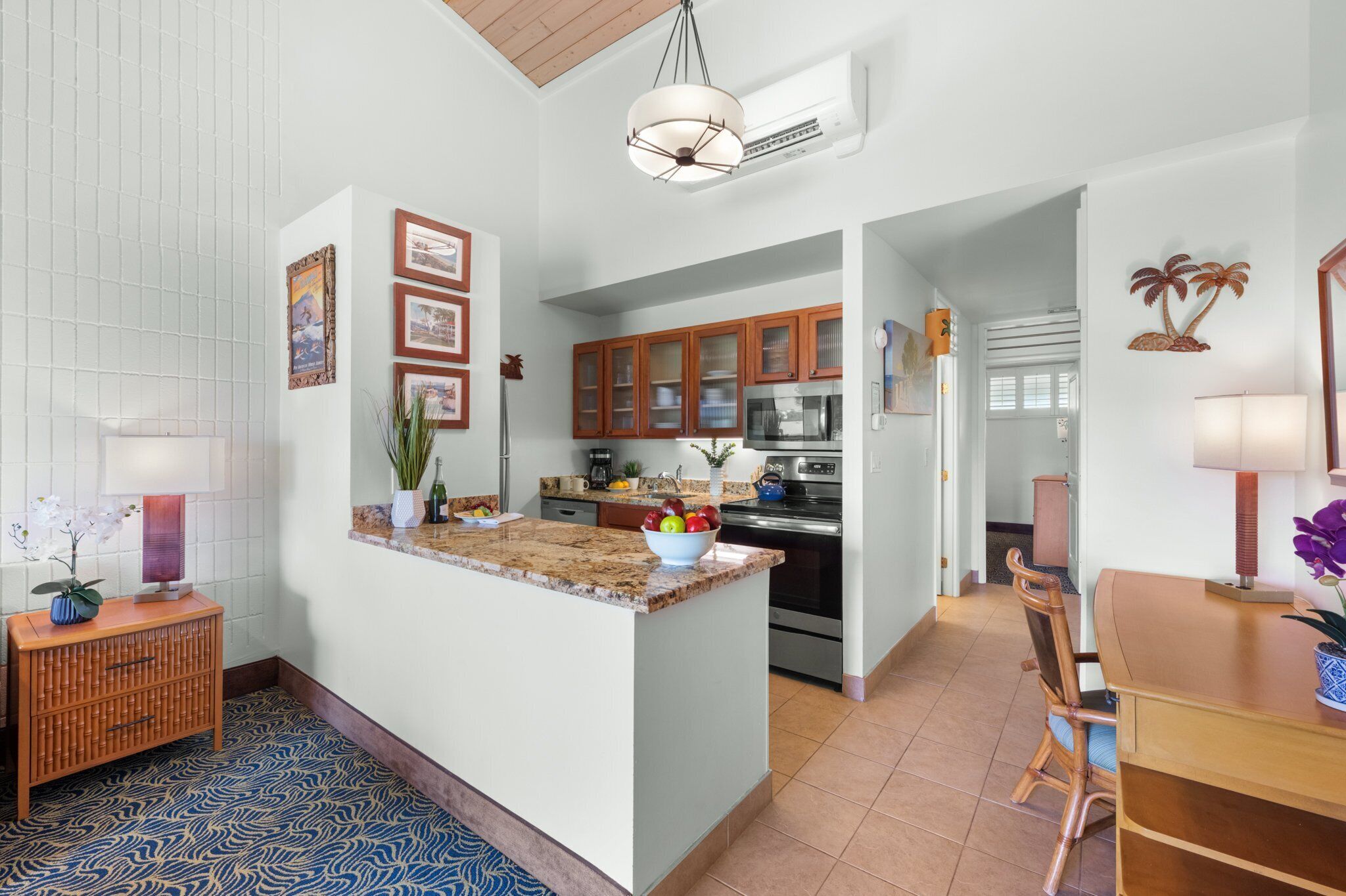 Una cocina moderna con encimeras de granito, armarios de madera y una isla central.