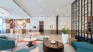 A modern lobby with seating areas, a reception desk, and a staircase. - Belmont Hotel Iloilo (Mandurriao)