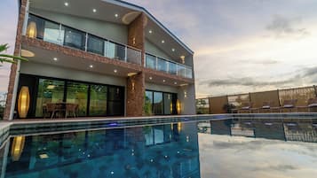Una piscina al aire libre, sillones reclinables de piscina