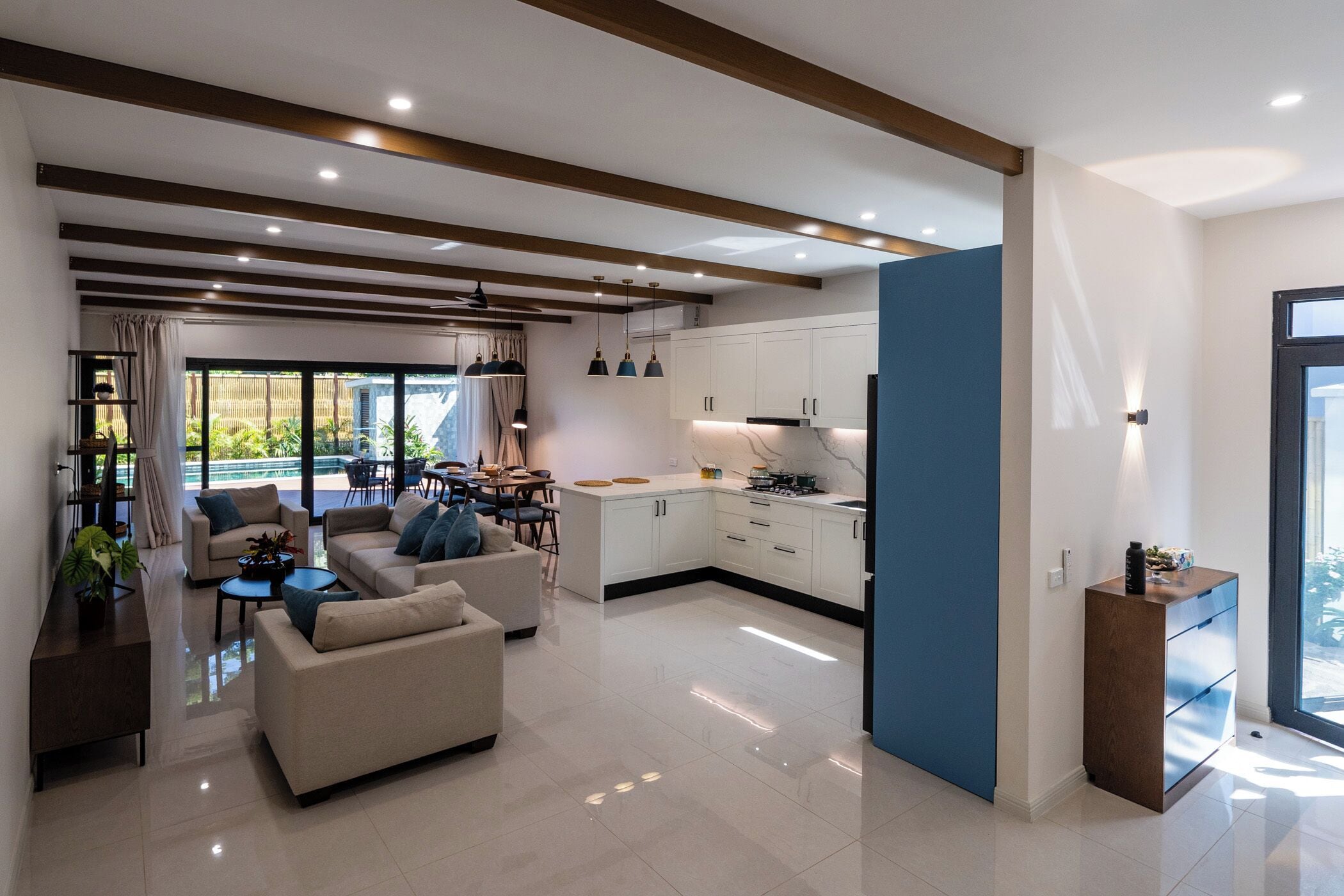 Een moderne woonkamer met een bank, salontafel en eethoek.