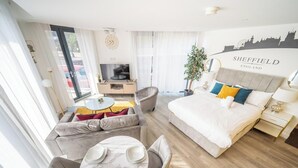 A hotel room with a bed, a sofa, a TV, a desk, and a plant. - Chic Studio | Prime Location | Free Parking (Sheffield)