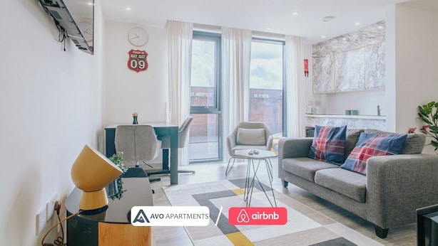 A modern apartment with a dining area, a sofa, and a kitchen. - Comfy Studio Apartment in Heart of Sheffield (Sheffield)