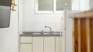 Cocina con armarios blancos, encimera de granito, pileta de acero inoxidable y una ventana sobre la pileta.