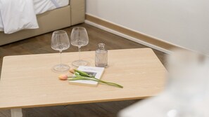 A wooden table with two wine glasses, a bottle, a book, and a tulip. - Goseong Jajackdo Aroma Pension (Goseong)